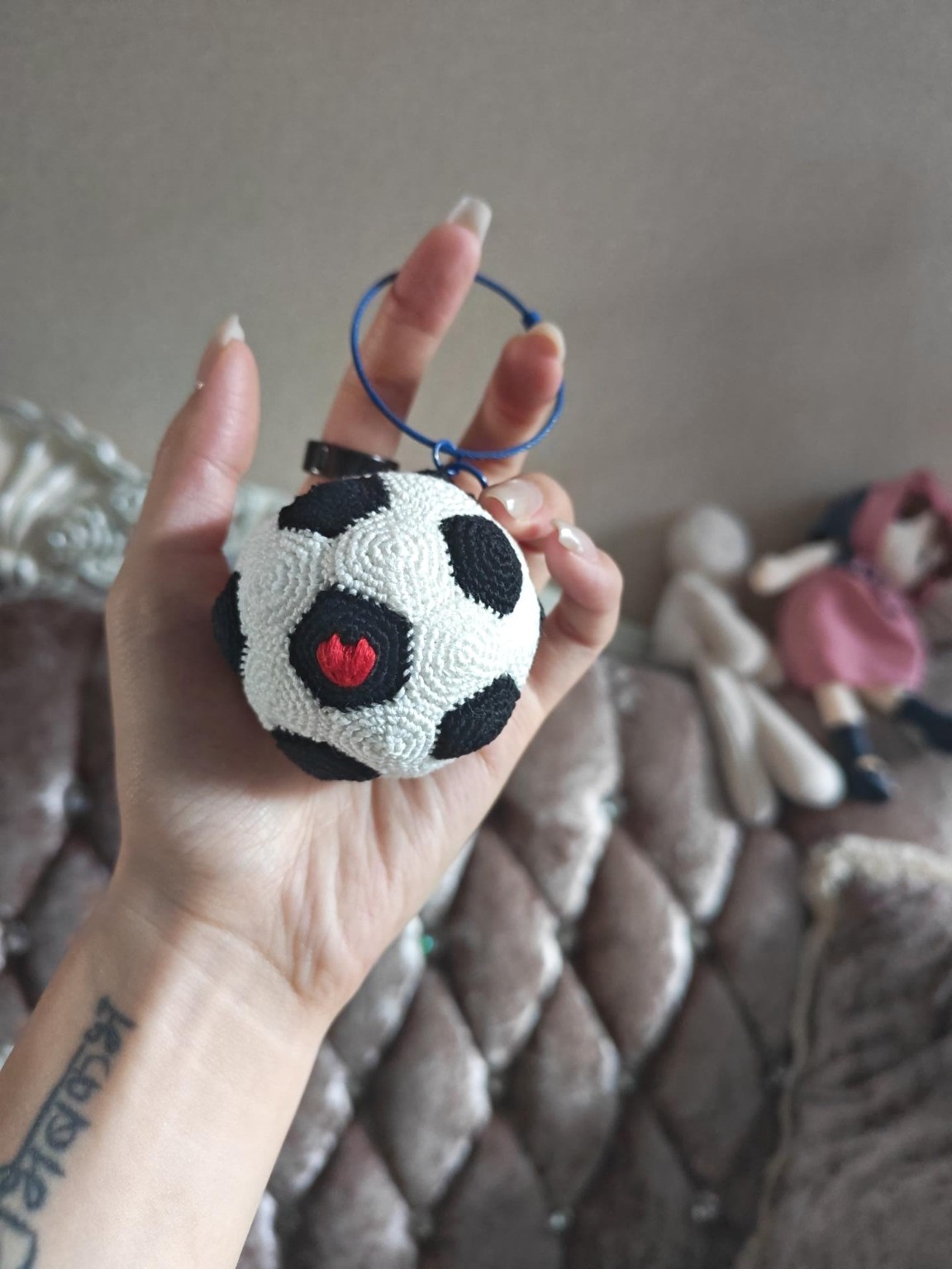 A handmade football keychain with a red heart